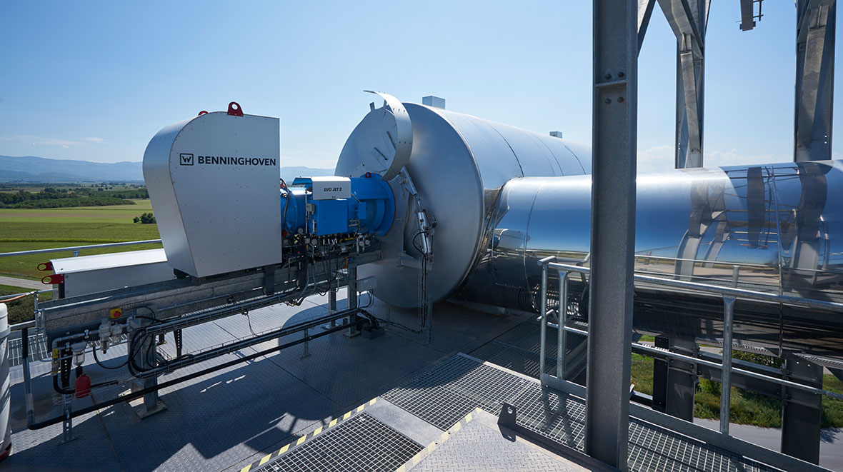 Der Brenner fährt auf seinem Fahrgestell, je nach Betriebszustand automatisch vor und zurück. Im Nachgang hierzu fährt eine Abschottung ein- bzw. aus. Dieses Prozedere ist speziell dafür entwickelt worden, damit nach Ausschalten der Feuerung der Brenner keinen Schaden erleidet. Durch die Kaminwirkung und damit verbunden durch die aufsteigende heiße Luft aus der Recyclingtrommel, wäre der Brenner nicht geschützt. Wird der Brenner wieder gestartet, fährt die Abschottung aus und die gesamte Einheit in die Betriebsstellung.