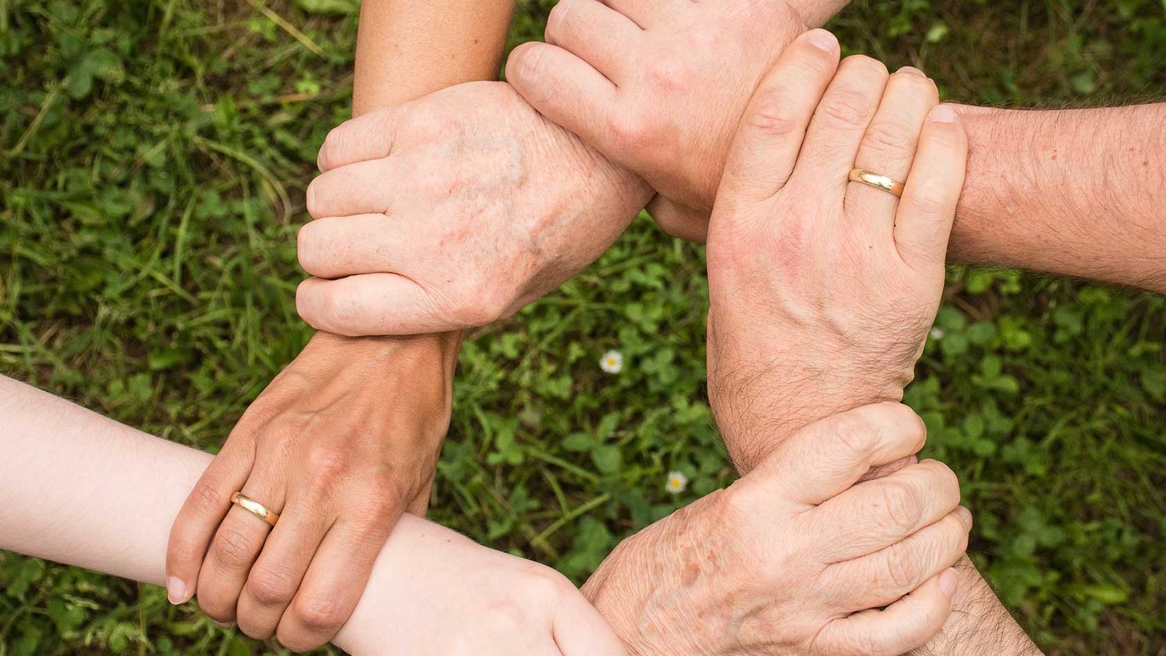 Circle of five hands representing the concept of community