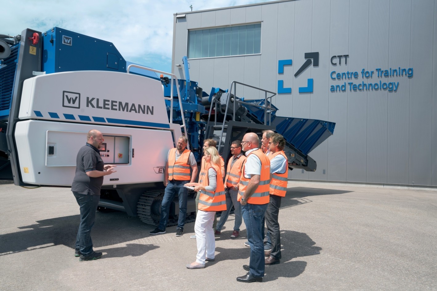 Training group with safety vests in front of Kleemann machine