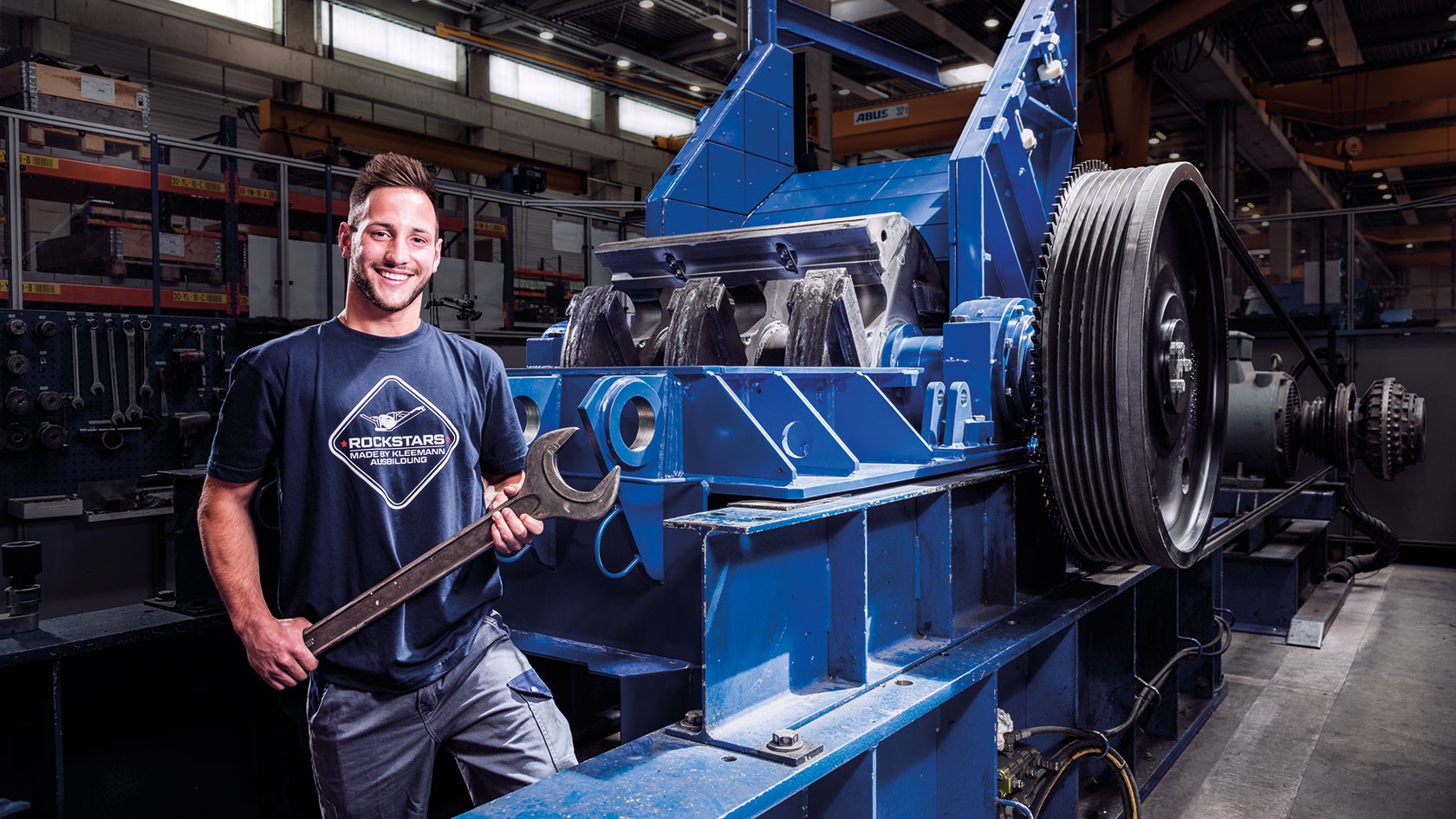 Kleemann apprentice in front of Kleemann crusher with large spanner in hand