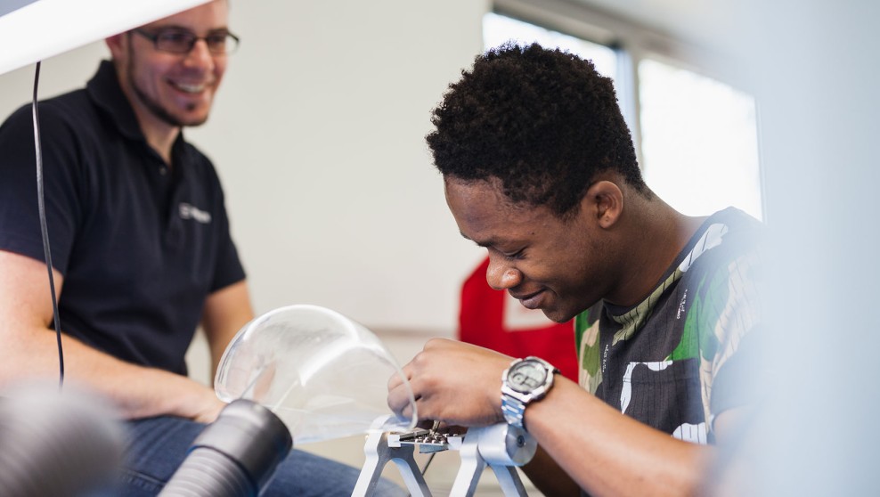 Young trainee at work with a trainer in the background