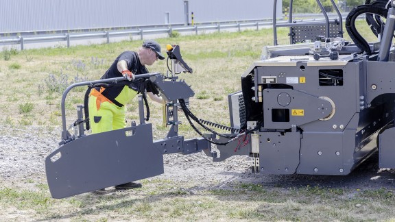 A screed operator swivels the side plate into the desired position