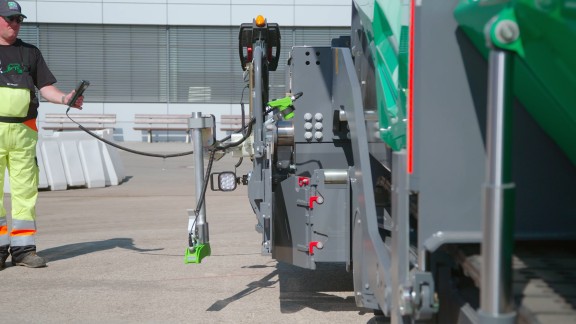 A screed operator adjusts the limiting plate for the auger tunnel using the remote control