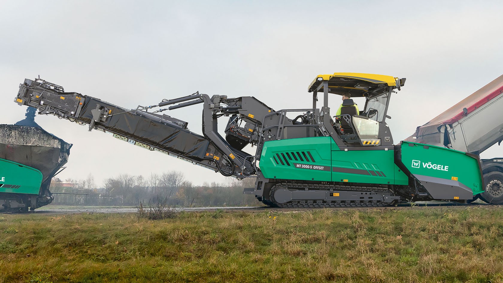The picture shows a VÖGELE PowerFeeder with assistance systems at work.