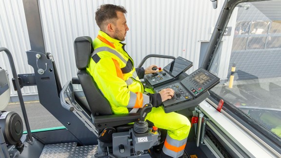 The photo shows the seated operator on an ErgoPlus 5 operator’s platform.