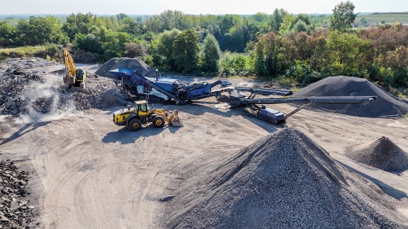 The mobile Kleemann impact crusher MOBIREX MR 130 EVO in operation, feeding two downstream Kleemann stackers