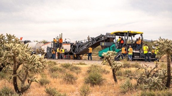 Construction site in the desert in the USA where a Vögele Super 2000-3i is loaded by a Wirtgen recycler