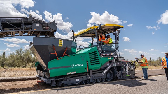Construction site in the desert in the USA where a Vögele Super 2000-3i is loaded by a Wirtgen recycler