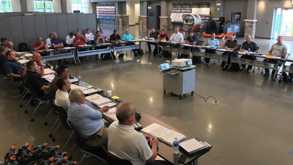Trainer explaining a WIRTGEN GROUP machine to a group in front of the CTT.