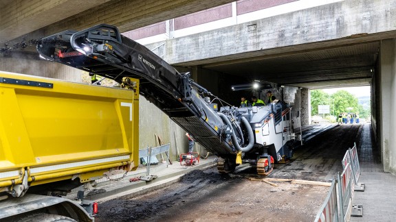 Trainees working under a bridge with the Wirtgen large milling machine W 120 Fi.