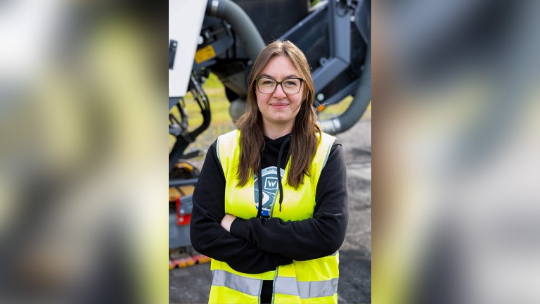 Portrait photo of a young woman wearing a hi-vis safety vest