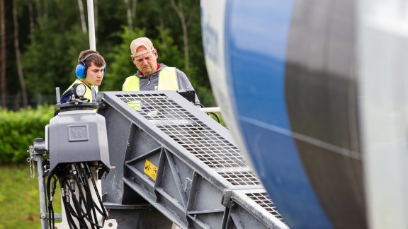 The instructor and a trainee behind the Wirtgen slipform paver. The instructor provides explanations.
