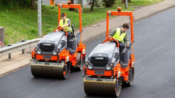 Trainees compact the asphalt with two Hamm rollers driven in parallel.