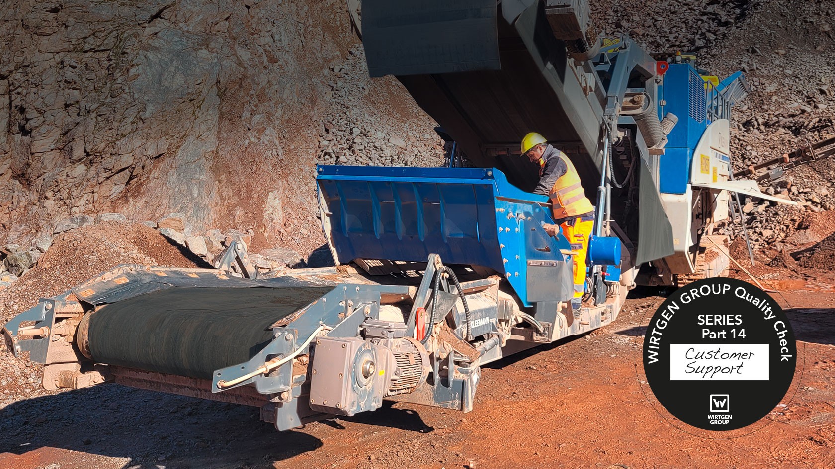 Вид сбоку на дробилку в карьере Находящийся на дробильной установке рабочий заглядывает внутрь дробилки. 