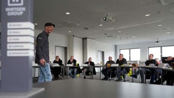 Group of machine users listening to an instructor in a training classroom.