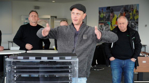 The instructor explains with gestures; two other people at the right and left.