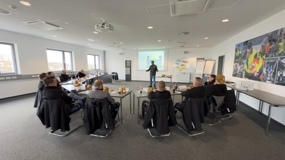 Group of machine users listening to an instructor in a training classroom.
