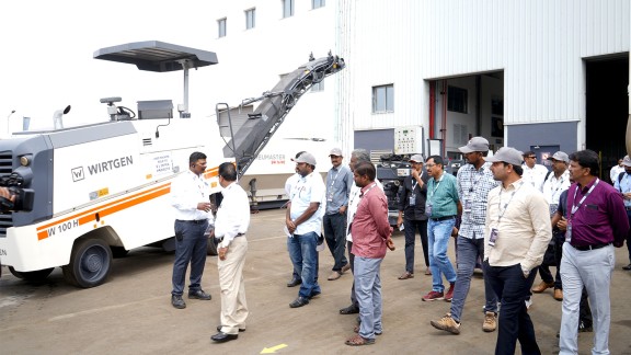 Participants in front of a Wirtgen milling machine