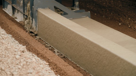 Gros plan sur le nouveau profil de bordures de trottoir et de rigoles. Ici : pose du coffrage. 