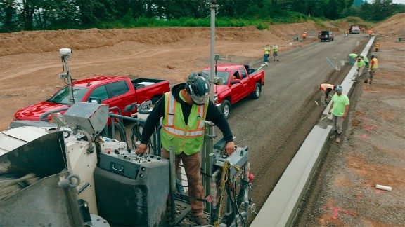 Un travailleur se tient au niveau du poste de conduite d’où il contrôle le résultat de la pose.