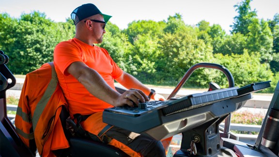 The paver operator looks down at the road during paving.
