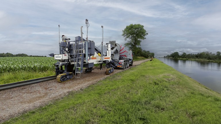 Wirtgen machine on a farm track by a small stream.