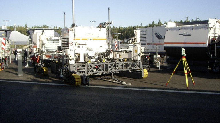 Archive photo: Wirtgen machines with a legacy logo and a total station.