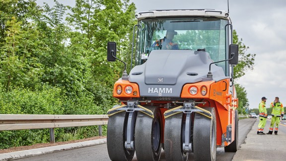 A pneumatic-tyre roller seals each of the two paved layers 