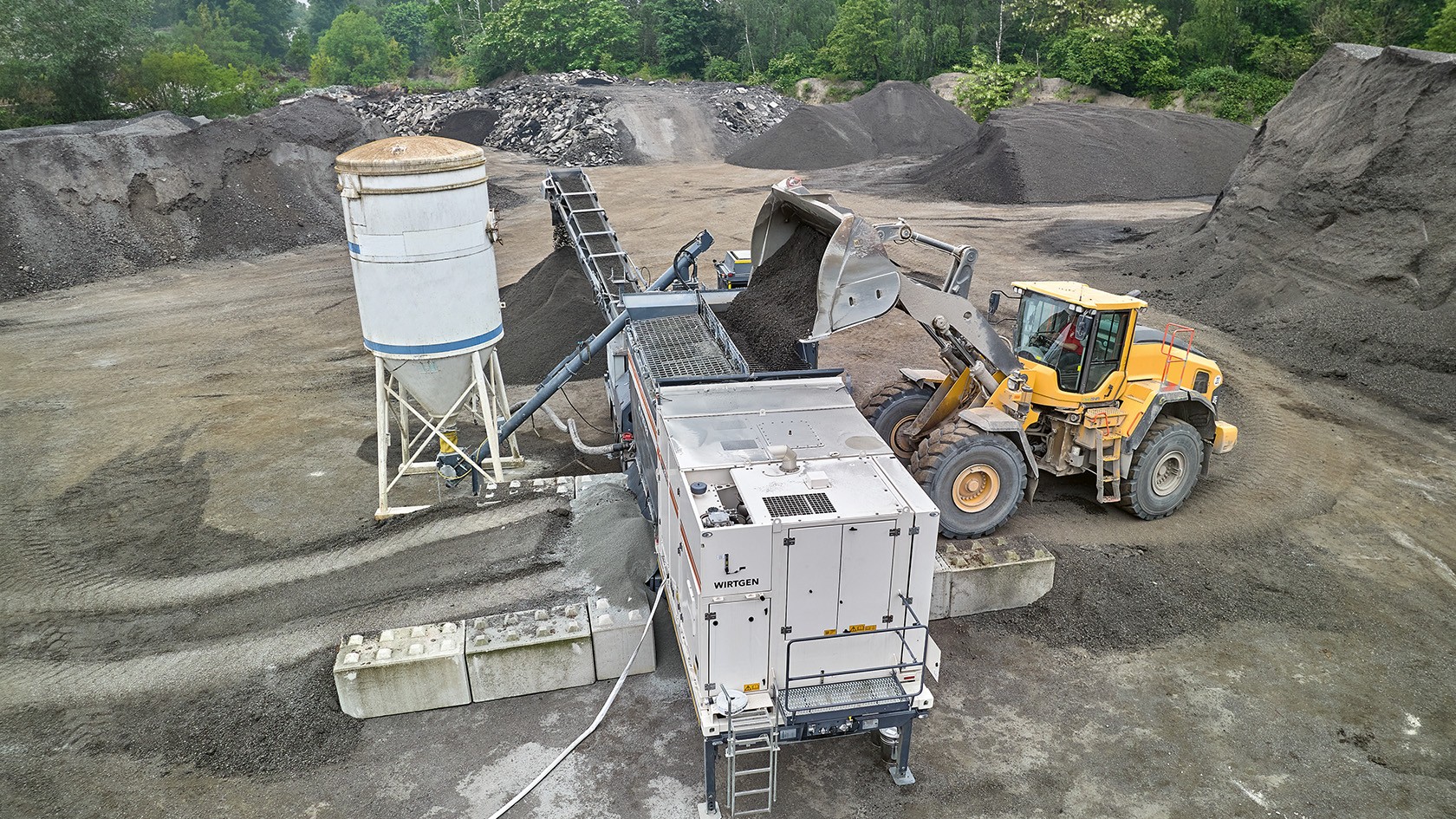 Wheel loader feeding material to the cold recycler.