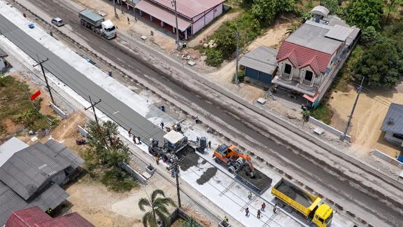 The Tha Sala project site; aerial view; an excavator and a truck in front of the SP 64