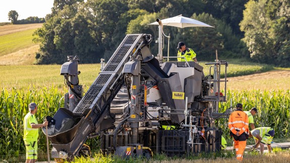 SP 33 paving two-track road profiles in Sieghartskirchen with meadows and fields in the background