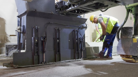SP 33 paving the kerb-gutter profile in the Semmering Tunnel with a worker standing alongside checking the results