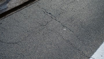 View of the asphalt surface showing the countless cracks.