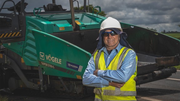 Picture of Otair Castro de Melo, paver operator at Val Rocha Engenharia, standing in front of the SUPER 2100-5 X.