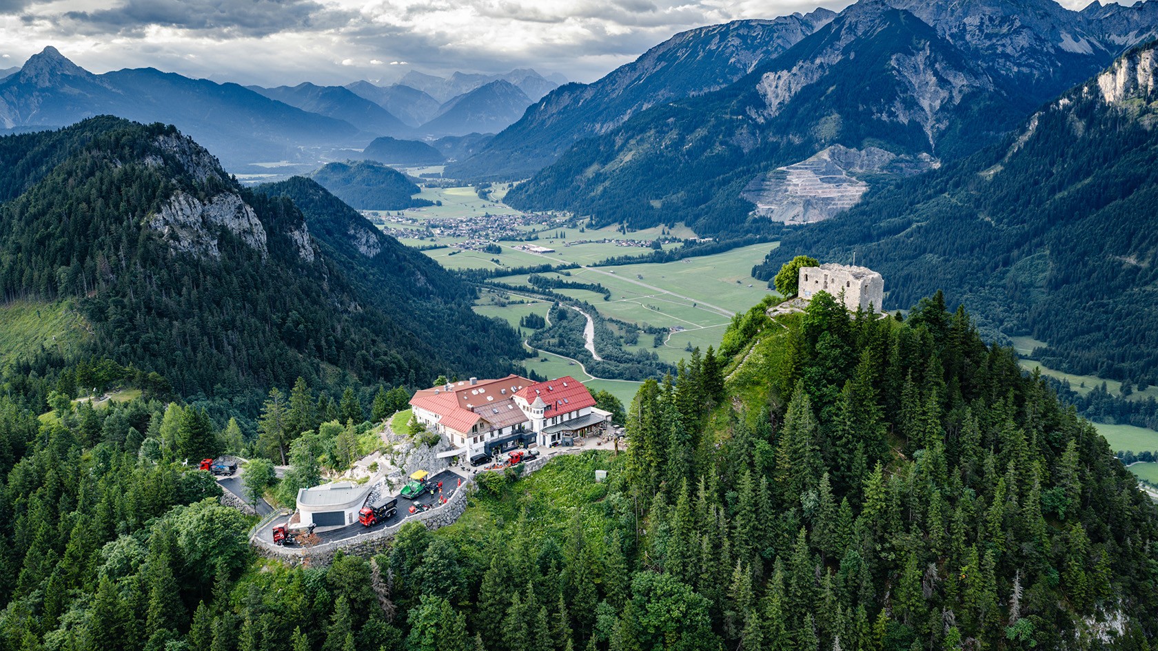 Le rovine di un castello e un po’ più a valle un piccolo hotel. Sulla strada di accesso, lavori di ripristino. Sullo sfondo, un panorama montano boscoso