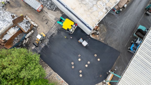 Supervision of a freshly asphalted area with eleven manhole covers.