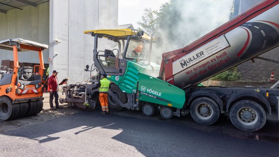 Vögele paver being filled with mix, side view.