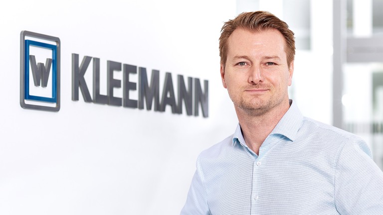 Portrait of Jörg Schaudig, Product Manager for Digital Solutions at Kleemann, standing beside Kleemann brand lettering.