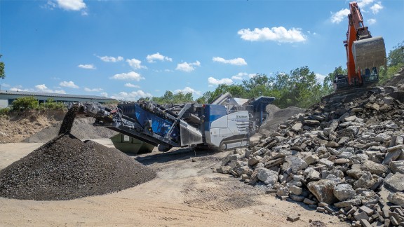 Il frantoio a urto mobile schiaccia grandi blocchi di detriti in materiali da costruzione riciclati.