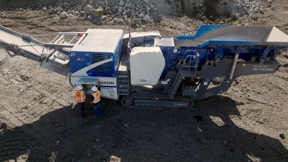 Side view of the MC 110i EVO2 at work on Big Island, Hawaii, with two people standing in front of the SPECTIVE touch screen