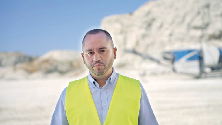 Man in a high-visibility jacket looks seriously into the camera