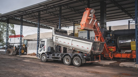 Truck waiting to be filled by the Ciber asphalt mixing plant, profile view from the left.