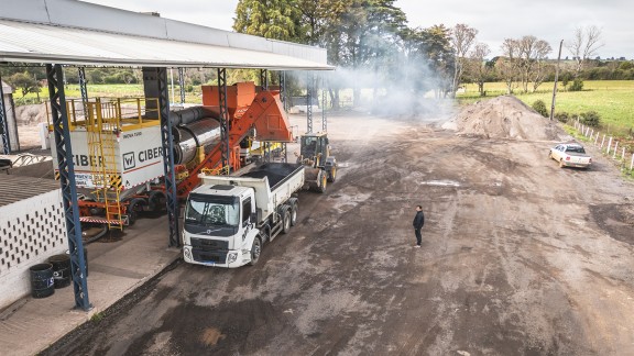 Asphalt is filled into a waiting truck. View from the front at an angle.