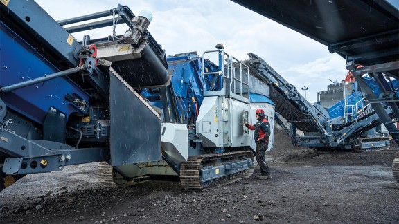 El conductor de la instalación se encuentra junto a la abertura de manejo de SPECTIVE y mira concentrado la superficie de manejo.