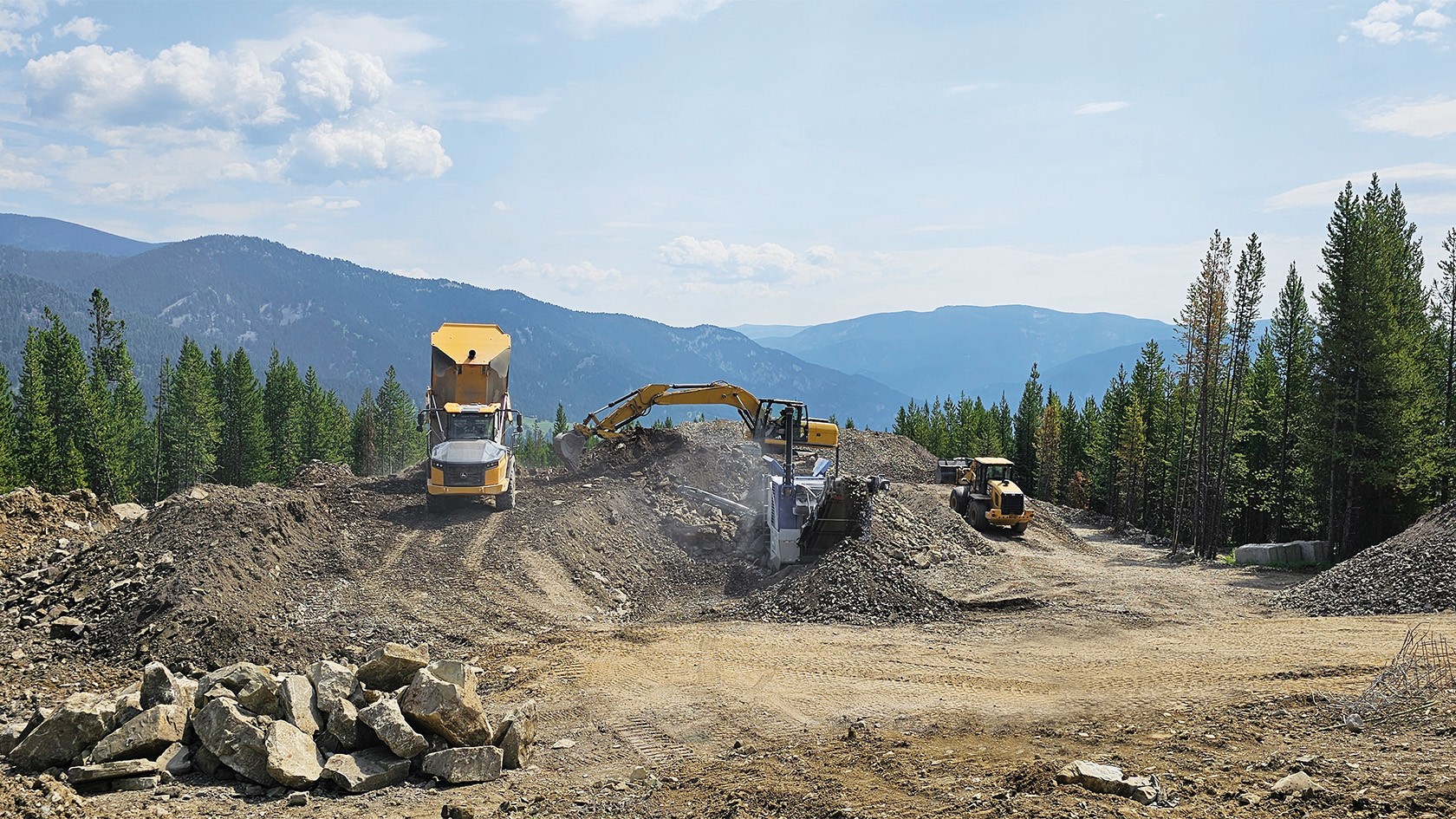 Jaw crusher stands between piles of material that still needs to be crushed.