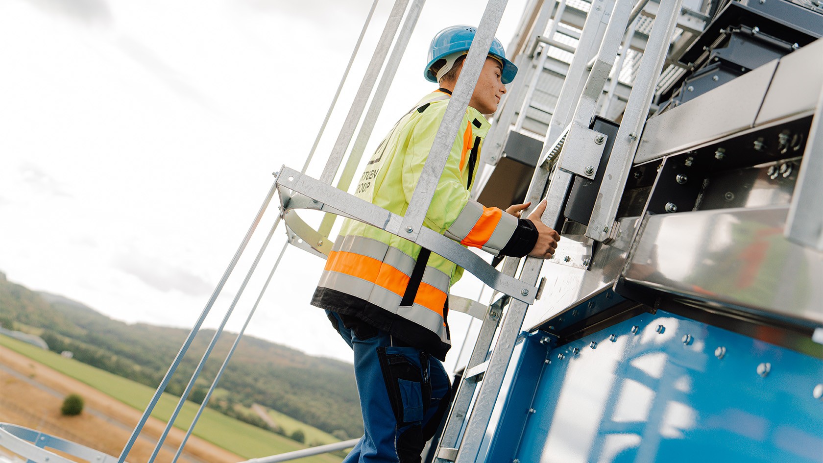 An apprentice climbs in an accessway protected by railings on the CORE mixing tower.