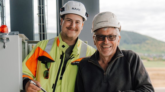 Group photo: trainee and assembly supervisor smile for the camera.