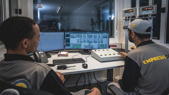 Two men sitting in front of screens, BLS plant control system