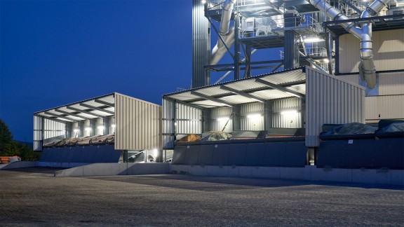 Illuminated feed units at night against an intense dark blue sky