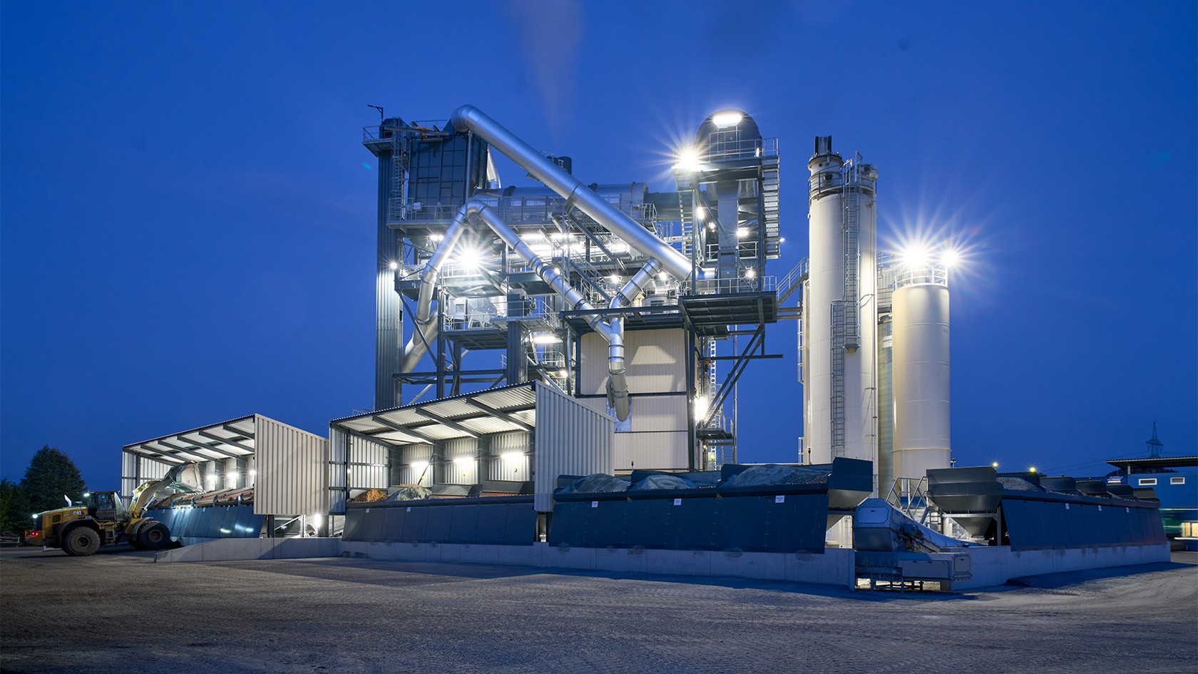Front view of the RPP 3000 Plus in Luhe-Wildenau, late evening, the plant is lit up under a deep blue sky.